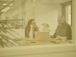Tom and Keeley in the office, meeting room 2, on a call, yellow image overlay
