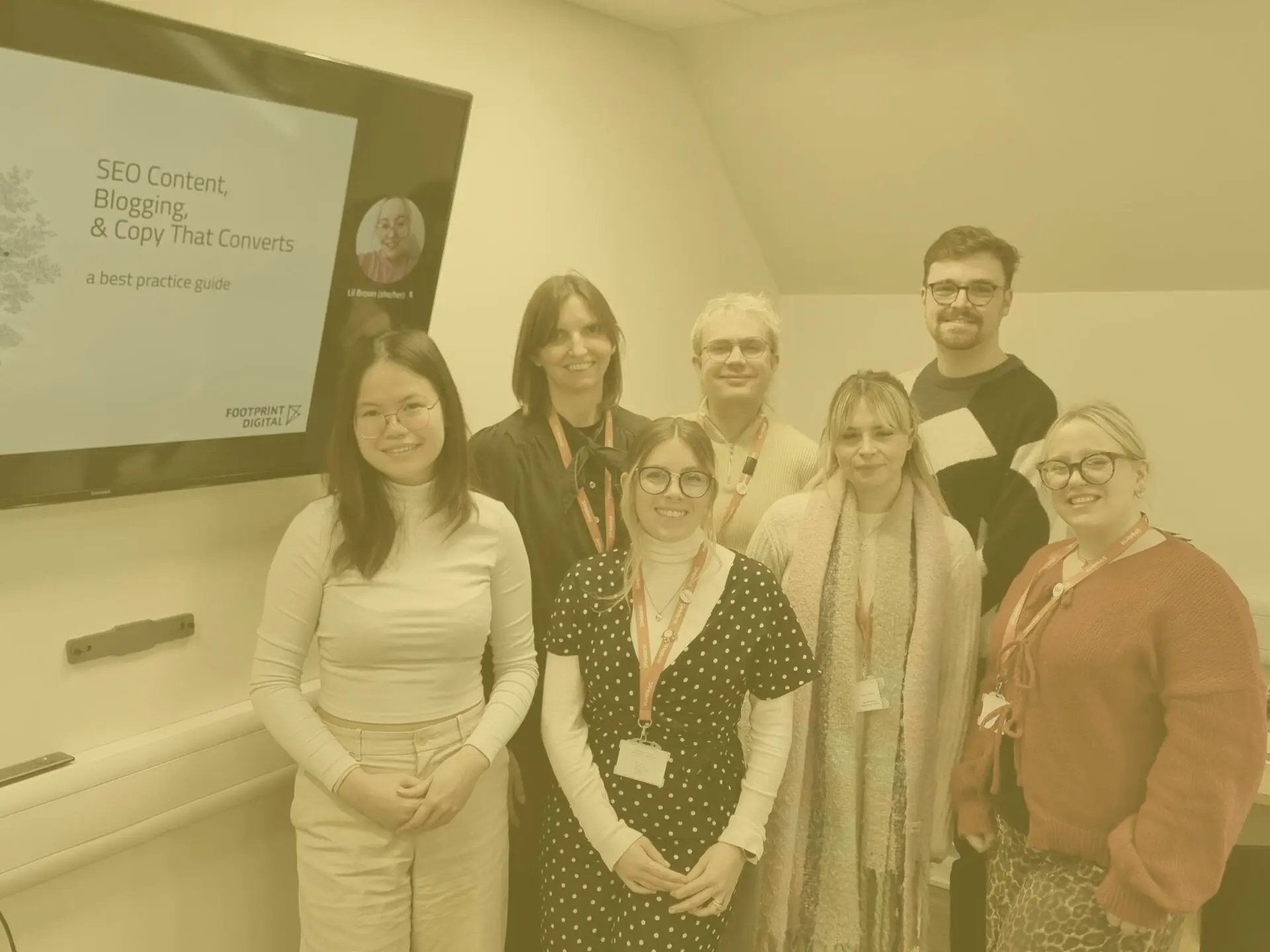 Kieran and group of trainees at content session with yellow image overlay