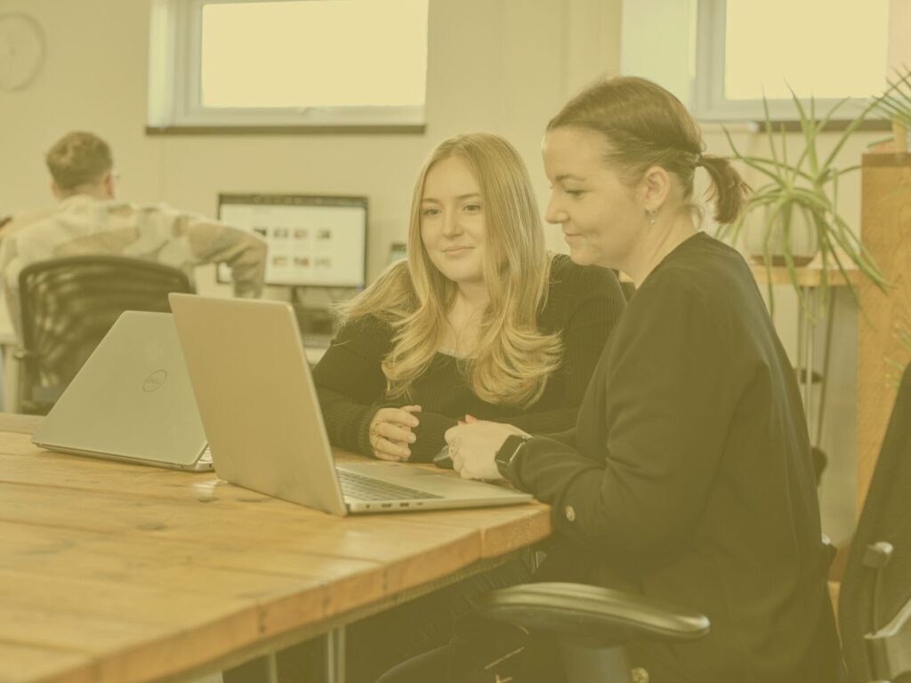 Issy and Crystal in main office with yellow image overlay