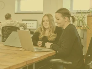 Issy and Crystal in main office with yellow image overlay