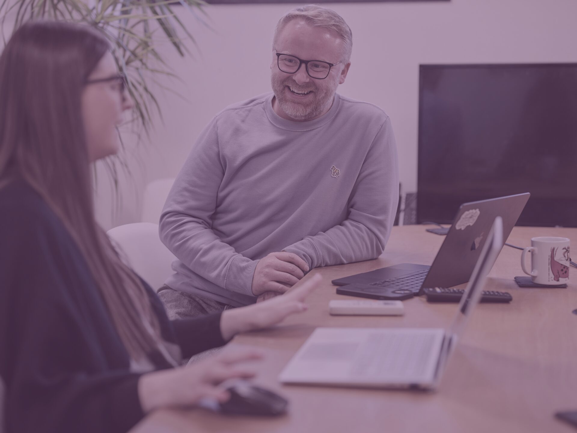 Charlotte and Sam in office meeting room with purple image overlay