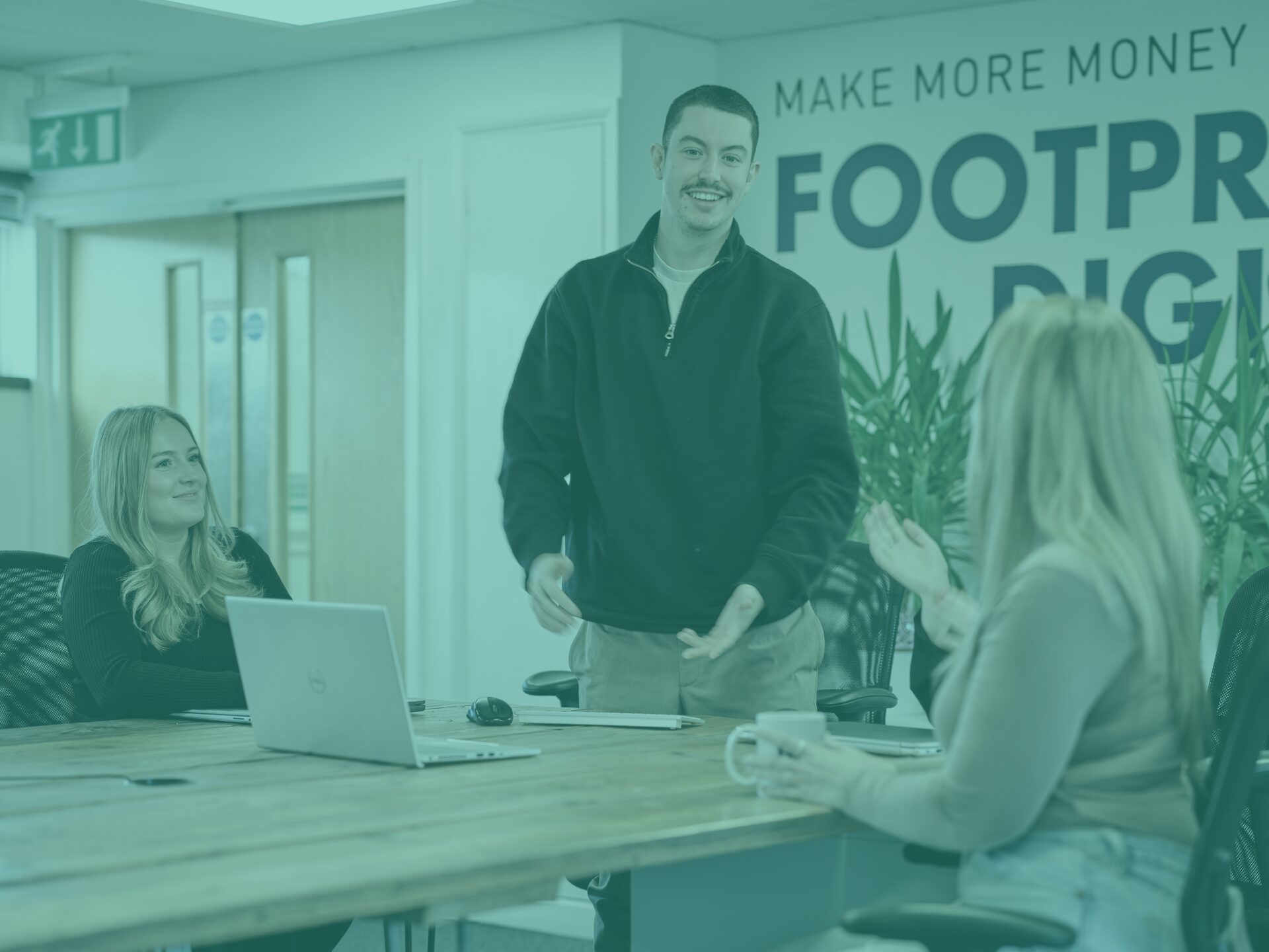 Kieran, Issy, and Charlotte in main office room with teal image overlay