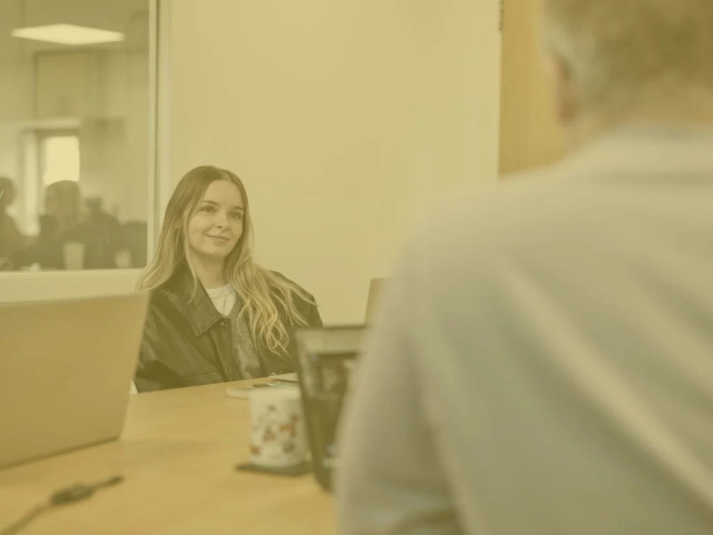 Klaudia in office meeting room with yellow image overlay
