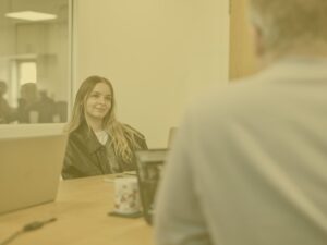 Klaudia in office meeting room with yellow image overlay