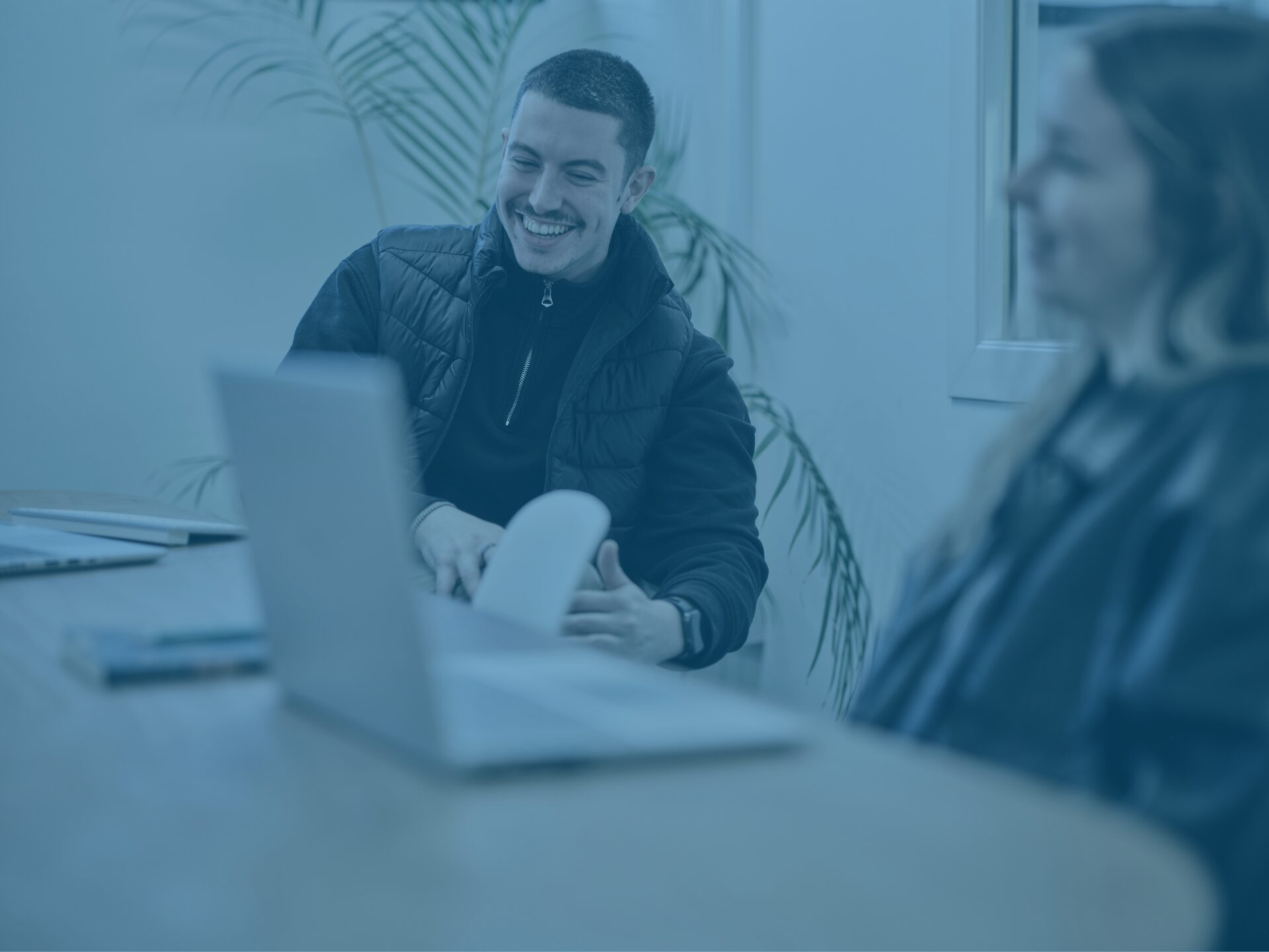 Kieran and Klaudia in office meeting room with blue image overlay