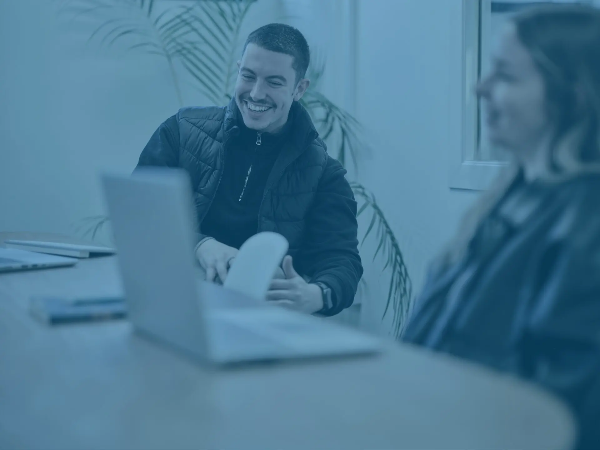 Kieran and Klaudia in office meeting room with blue image overlay