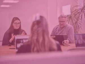 Charlotte and sam in office meeting room with pink image overlay